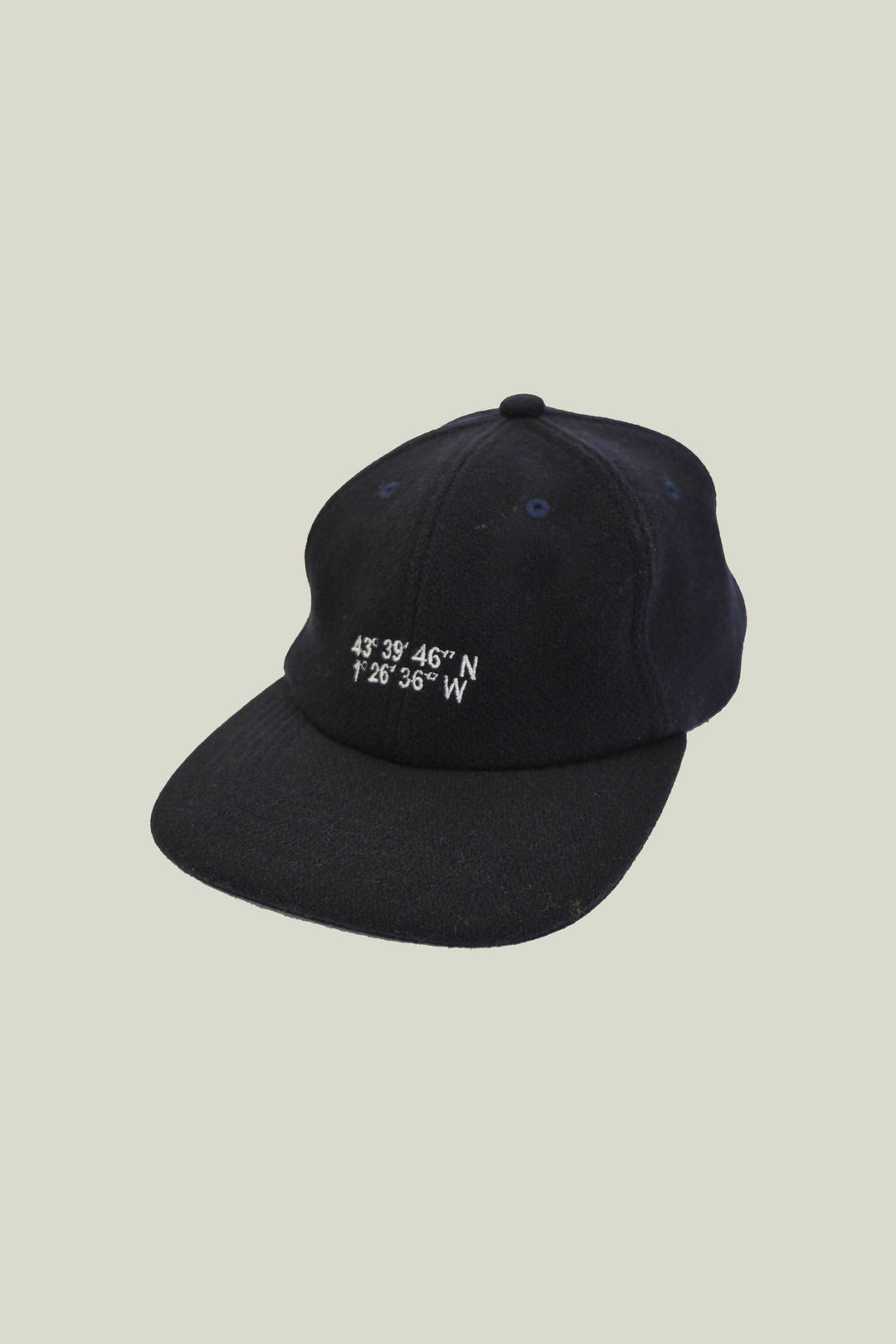 Casquette tartan marine avec lanière en cuir marron et fermeture en metal à l'arrière.