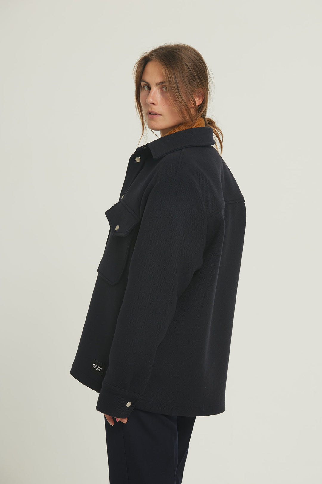 Notre surchemise "Cold Morning" est une veste en laine mélangée bleu marine. Porté par une femme. 